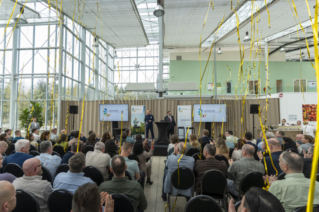 Confetti wordt afgeschoten in een zaal met mensen